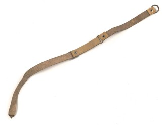 Kinnriemen für einen Tropenhelm der Wehrmacht. An der Befestigung ausgerissen, Gesamtlänge wie fotografiert 44cm. Ungereinigt, leicht angetrocknet