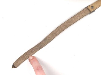 Kinnriemen für einen Tropenhelm der Wehrmacht. An der Befestigung ausgerissen, Gesamtlänge wie fotografiert 44cm. Ungereinigt, leicht angetrocknet
