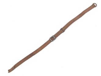 Kinnriemen für einen Tropenhelm der Wehrmacht. An der Befestigung ausgerissen, Gesamtlänge wie fotografiert 45cm. Ungereinigt, leicht angetrocknet