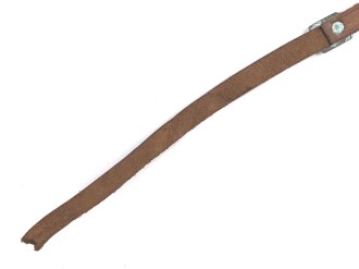 Kinnriemen für einen Tropenhelm der Wehrmacht. An der Befestigung ausgerissen, Gesamtlänge wie fotografiert 45cm. Ungereinigt, leicht angetrocknet