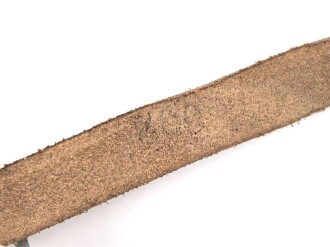 Kinnriemen für einen Tropenhelm der Wehrmacht. An der Befestigung ausgerissen, Gesamtlänge wie fotografiert 45cm. Ungereinigt, leicht angetrocknet