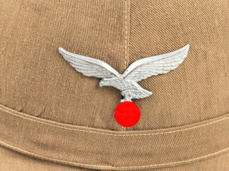 Afrikakorps, Tropenhelm für Angehörige der Luftwaffe. Ursprünglich französischer Helm von 1939, als Beutestück in die Wehrmacht übernommen. Guter Gesamtzustand, die Effekten original ? Kopfgrösse 57