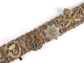 British most likely WWII , 12 cap badges attached to hand made belt. Uncleaned