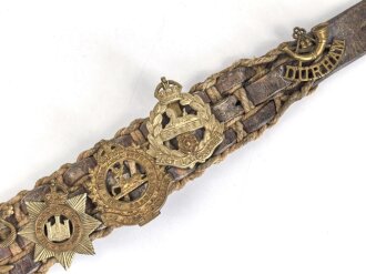 British most likely WWII , 12 cap badges attached to hand made belt. Uncleaned