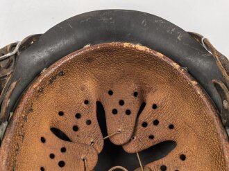 Heer, Stahlhelm Modell 1942. In allen Teilen original , das Innenfutter vermutlich in der Zeit gewechselt, früher Kinnriemen ergänzt, das Hakenkreuz vollständig erhalten. Hersteller EF 64. Ungereinigt