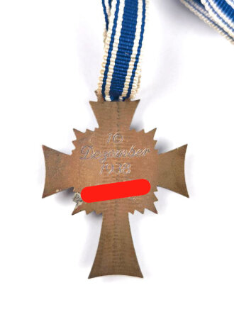 Ehrenkreuz der Deutschen Mutter in bronze, an langem Band. Nicht verausgabtes Stück, aus altem Bestand eines höchstwahrscheinlich Österreichischen Herstellers.