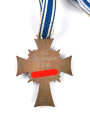 Ehrenkreuz der Deutschen Mutter in bronze, an langem Band. Nicht verausgabtes Stück, aus altem Bestand eines höchstwahrscheinlich Österreichischen Herstellers.