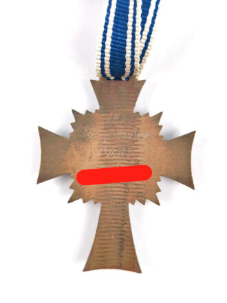 Ehrenkreuz der Deutschen Mutter in bronze, an langem Band. Nicht verausgabtes Stück, aus altem Bestand eines höchstwahrscheinlich Österreichischen Herstellers.