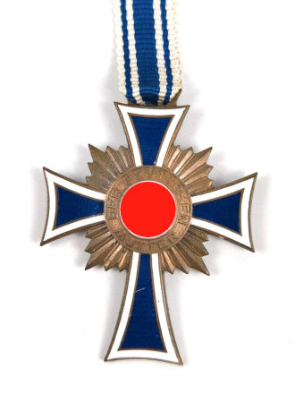 Ehrenkreuz der Deutschen Mutter in bronze, an langem Band. Nicht verausgabtes Stück, aus altem Bestand eines höchstwahrscheinlich Österreichischen Herstellers.