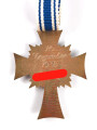 Ehrenkreuz der Deutschen Mutter in bronze, an langem Band. Nicht verausgabtes Stück, aus altem Bestand eines höchstwahrscheinlich Österreichischen Herstellers.