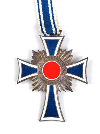 Ehrenkreuz der Deutschen Mutter in bronze, an langem Band. Nicht verausgabtes Stück, aus altem Bestand eines höchstwahrscheinlich Österreichischen Herstellers.