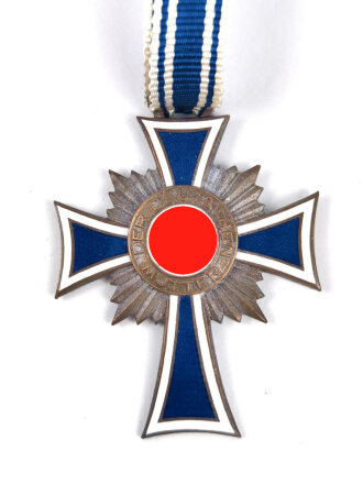 Ehrenkreuz der Deutschen Mutter in bronze, an langem Band. Nicht verausgabtes Stück, aus altem Bestand eines höchstwahrscheinlich Österreichischen Herstellers.