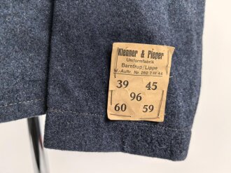 Fliegerbluse für Angehörige der Luftwaffe. Ungetragenes Stück mit Etikett von "Klenner & Pieper Uniformfabrik Barntrup/ Lippe". Ein Loch im unteren bereich hinten, sonst sehr guter Zustand