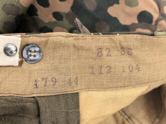Waffen SS, Tarnhose in der seltenen " glatten" Baumwollausführung. Ungetrages Kammerstück vom Hersteller 179, datiert 1944. In dieser Qualität sehr selten