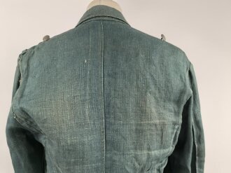 Feldbluse in Drillichmaterial. Heeresschnitt, aber eher Polizeigrünes Material. Weder Brust- noch Ärmeladlerabdruck, dafür deutliche , relativ große Kragenspiegelabdrücke. Getragenes Kammerstück