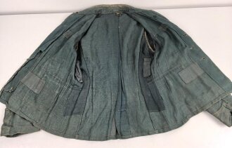 Feldbluse in Drillichmaterial. Heeresschnitt, aber eher Polizeigrünes Material. Weder Brust- noch Ärmeladlerabdruck, dafür deutliche , relativ große Kragenspiegelabdrücke. Getragenes Kammerstück