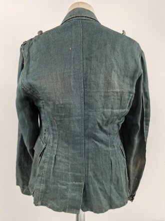 Feldbluse in Drillichmaterial. Heeresschnitt, aber eher Polizeigrünes Material. Weder Brust- noch Ärmeladlerabdruck, dafür deutliche , relativ große Kragenspiegelabdrücke. Getragenes Kammerstück