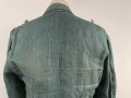Feldbluse in Drillichmaterial. Heeresschnitt, aber eher Polizeigrünes Material. Weder Brust- noch Ärmeladlerabdruck, dafür deutliche , relativ große Kragenspiegelabdrücke. Getragenes Kammerstück