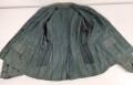 Feldbluse in Drillichmaterial. Heeresschnitt, aber eher Polizeigrünes Material. Weder Brust- noch Ärmeladlerabdruck, dafür deutliche , relativ große Kragenspiegelabdrücke. Getragenes Kammerstück