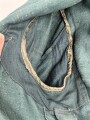 Feldbluse in Drillichmaterial. Heeresschnitt, aber eher Polizeigrünes Material. Weder Brust- noch Ärmeladlerabdruck, dafür deutliche , relativ große Kragenspiegelabdrücke. Getragenes Kammerstück