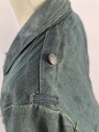 Feldbluse in Drillichmaterial. Heeresschnitt, aber eher Polizeigrünes Material. Weder Brust- noch Ärmeladlerabdruck, dafür deutliche , relativ große Kragenspiegelabdrücke. Getragenes Kammerstück
