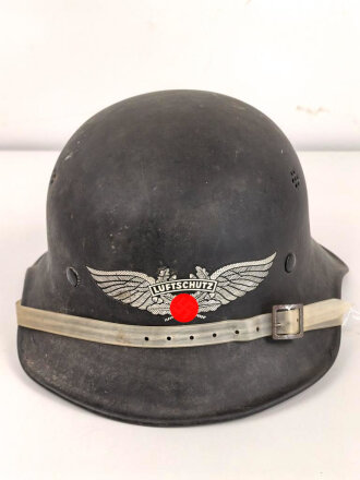 Stahlhelm Luftschutz, einteiliges Modell mit Kinnriemen aus Kuststoff und Zugband aus Webmaterial. Seitlich kann man schemenhaft reste von Abzeichen erkennen, vorne " Luftschutz" Emblem Original ?