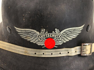 Stahlhelm Luftschutz, einteiliges Modell mit Kinnriemen aus Kuststoff und Zugband aus Webmaterial. Seitlich kann man schemenhaft reste von Abzeichen erkennen, vorne " Luftschutz" Emblem Original ?