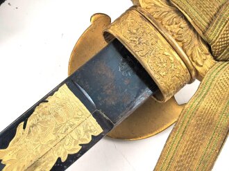 Hirschfänger mit Feldbinde und Koppelschuh in Luxusausführung. Der Hirschfänger von Eickhorn Solingen mit einer Gesamtlänge von 77cm in gutem Zustand, das Porteppe mit grünen Durchzügen.