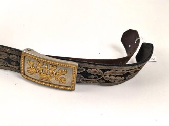 Hirschfänger mit Feldbinde und Koppelschuh in Luxusausführung. Der Hirschfänger von Eickhorn Solingen mit einer Gesamtlänge von 77cm in gutem Zustand, das Porteppe mit grünen Durchzügen.