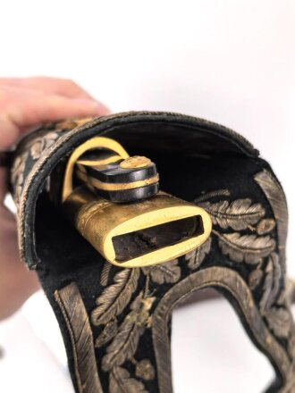 Hirschfänger mit Feldbinde und Koppelschuh in Luxusausführung. Der Hirschfänger von Eickhorn Solingen mit einer Gesamtlänge von 77cm in gutem Zustand, das Porteppe mit grünen Durchzügen.