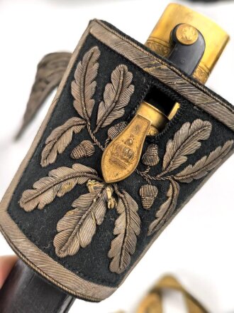 Hirschfänger mit Feldbinde und Koppelschuh in Luxusausführung. Der Hirschfänger von Eickhorn Solingen mit einer Gesamtlänge von 77cm in gutem Zustand, das Porteppe mit grünen Durchzügen.