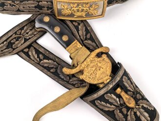 Hirschfänger mit Feldbinde und Koppelschuh in Luxusausführung. Der Hirschfänger von Eickhorn Solingen mit einer Gesamtlänge von 77cm in gutem Zustand, das Porteppe mit grünen Durchzügen.