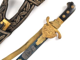 Hirschfänger mit Feldbinde und Koppelschuh in Luxusausführung. Der Hirschfänger von Eickhorn Solingen mit einer Gesamtlänge von 77cm in gutem Zustand, das Porteppe mit grünen Durchzügen.