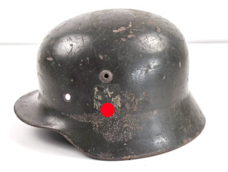 Heer, Stahlhelmglocke Modell 1935. Apfelgrüner, gedunkelter Originallack, das Hakenkreuz zu etwa 80% erhalten. Am Rand mit Splitterschaden. Ungereinigtes Stück, kein Hersteller erkannbar, Glockengrösse 66.