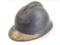 Frankreich 1. Weltkrieg, Stahlhelm Adrian Modell 1915 . Originallack, das Emblem fehlt. Um 1919 zusätzlich angebrachte Emblem " Soldat de la Grande Guerre 1914-1918" Originallack, das Innenfutter zum Teil lose, Kinnriemen gerissen