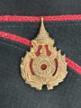 Thailand, grünes Schiffchen mit roter Biese und Metallabzeichen, guter Zustand