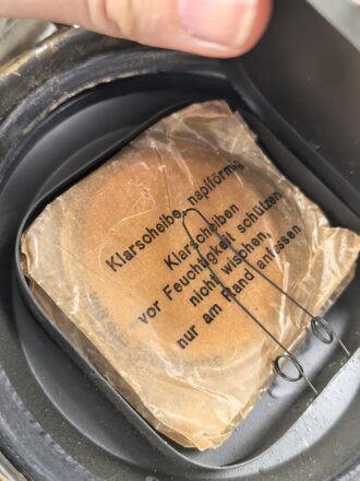 Gasmaske mit Filter in Bereitschaftsbüchse Modell 1938. Die Büchse original getarnt und gesandet, datiert 1942. Tropenausführung mit Gummiring. Die maske zugehörig, der unbenutzte Filter in Tropenausführung. Getragen, guter Gesamtzustand