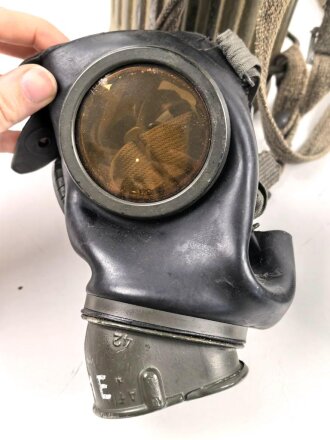 Gasmaske mit Filter in Bereitschaftsbüchse Modell 1938. Die Büchse original getarnt und gesandet, datiert 1942. Tropenausführung mit Gummiring. Die maske zugehörig, der unbenutzte Filter in Tropenausführung. Getragen, guter Gesamtzustand