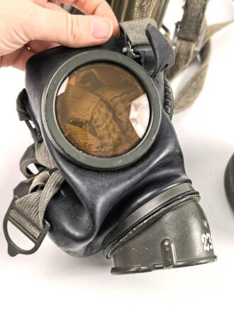 Gasmaske mit Filter in Bereitschaftsbüchse Modell 1938. Die Büchse original getarnt und gesandet, datiert 1942. Tropenausführung mit Gummiring. Die maske zugehörig, der unbenutzte Filter in Tropenausführung. Getragen, guter Gesamtzustand