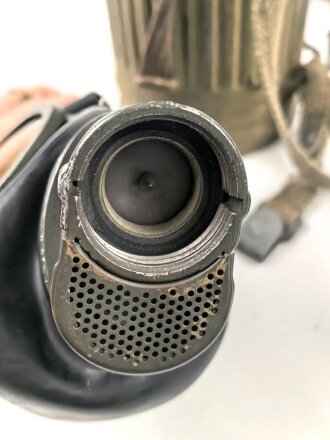 Gasmaske mit Filter in Bereitschaftsbüchse Modell 1938. Die Büchse original getarnt und gesandet, datiert 1942. Tropenausführung mit Gummiring. Die maske zugehörig, der unbenutzte Filter in Tropenausführung. Getragen, guter Gesamtzustand