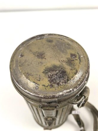 Gasmaske mit Filter in Bereitschaftsbüchse Modell 1938. Die Büchse original getarnt und gesandet, datiert 1942. Tropenausführung mit Gummiring. Die maske zugehörig, der unbenutzte Filter in Tropenausführung. Getragen, guter Gesamtzustand