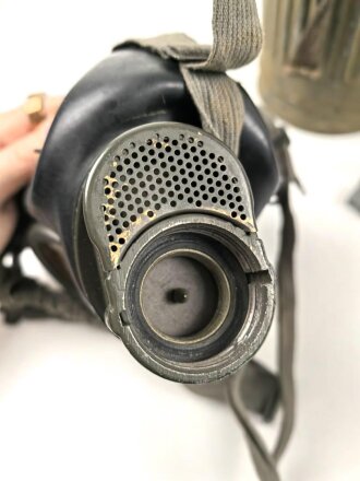 Gasmaske mit Filter in Bereitschaftsbüchse Modell 1938. Die Büchse original getarnt und gesandet, datiert 1942. Tropenausführung mit Gummiring. Die maske zugehörig, der unbenutzte Filter in Tropenausführung. Getragen, guter Gesamtzustand