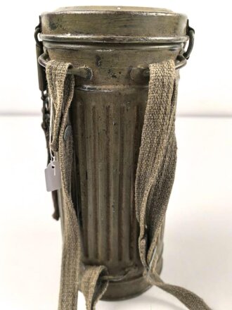 Gasmaske mit Filter in Bereitschaftsbüchse Modell 1938. Die Büchse original getarnt und gesandet, datiert 1942. Tropenausführung mit Gummiring. Die maske zugehörig, der unbenutzte Filter in Tropenausführung. Getragen, guter Gesamtzustand