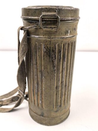 Gasmaske mit Filter in Bereitschaftsbüchse Modell 1938. Die Büchse original getarnt und gesandet, datiert 1942. Tropenausführung mit Gummiring. Die maske zugehörig, der unbenutzte Filter in Tropenausführung. Getragen, guter Gesamtzustand