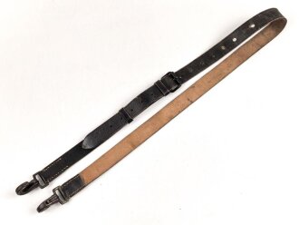 Lederriemen geschwärzt, lackierte Eisenschliesse, eiserne Karabinerhaken, Breite knapp 3cm, Länge etwa 125cm, Alter und Herkunft unbekannt