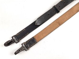 Lederriemen geschwärzt, lackierte Eisenschliesse, eiserne Karabinerhaken, Breite knapp 3cm, Länge etwa 125cm, Alter und Herkunft unbekannt