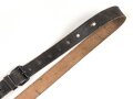 Lederriemen geschwärzt, lackierte Eisenschliesse, eiserne Karabinerhaken, Breite knapp 3cm, Länge etwa 125cm, Alter und Herkunft unbekannt