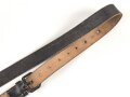 Lederriemen geschwärzt, lackierte Eisenschliesse, eiserne Karabinerhaken, Breite knapp 3cm, Länge etwa 125cm, Alter und Herkunft unbekannt