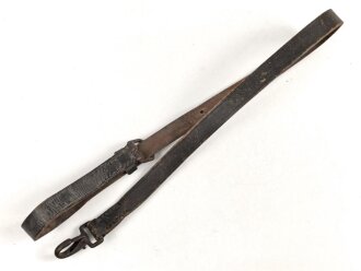 Lederriemen geschwärzt, lackierte Eisenschliesse, eiserner Karabinerhaken, Breite knapp über 2cm, Länge etwa 90cm, Alter und Herkunft unbekannt