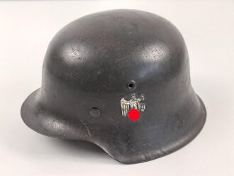 Stahlhelm Modell 1942 für Angehörige des Heeres. Original lackierte Glocke ckl64 , das Abzeichen vermutlich neuzeitlich ergänzt. Originales Innenfutter neuzeitlich ergänzt, originaler Kinnriemen.
